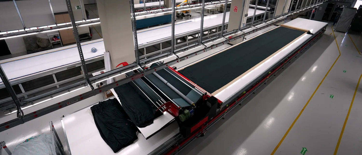 Cloth spread along the full length of the cutting table.
