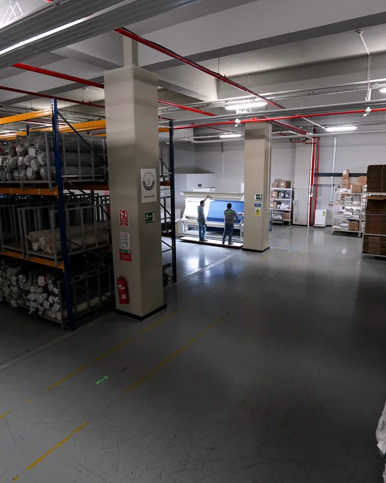 Rolled fabric on racking in the material warehouse.