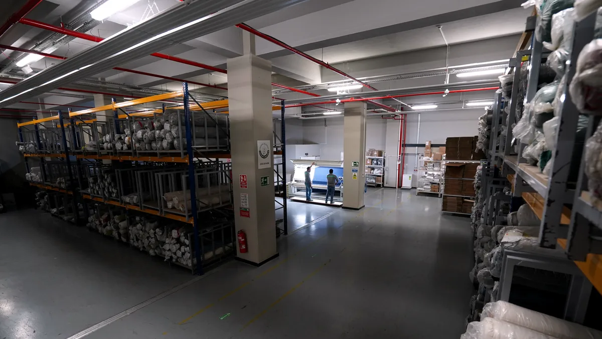 Rolled fabric on racking in the material warehouse.